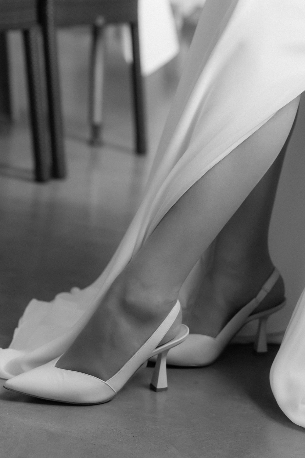 Artistic series of four black and white shots focusing on elegant white wedding shoes on a hardwood floor.
