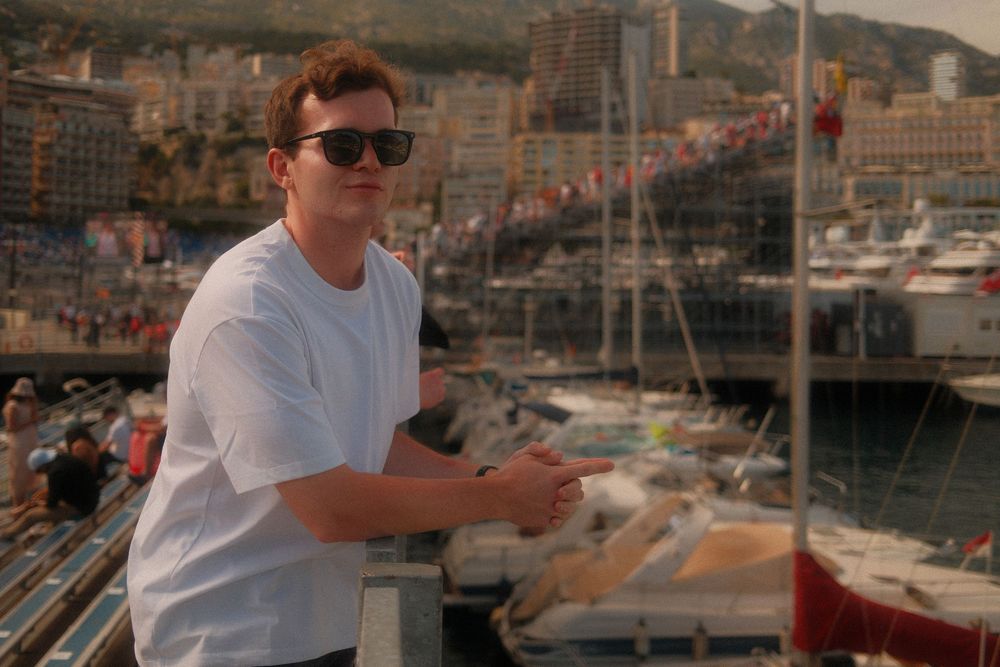 Scenic view of boats docked in a marina with mountains and buildings in the background.