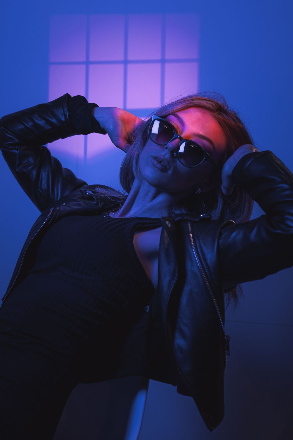 A silhouetted figure in sunglasses poses against a moody blue-lit background in a dynamic photo series.