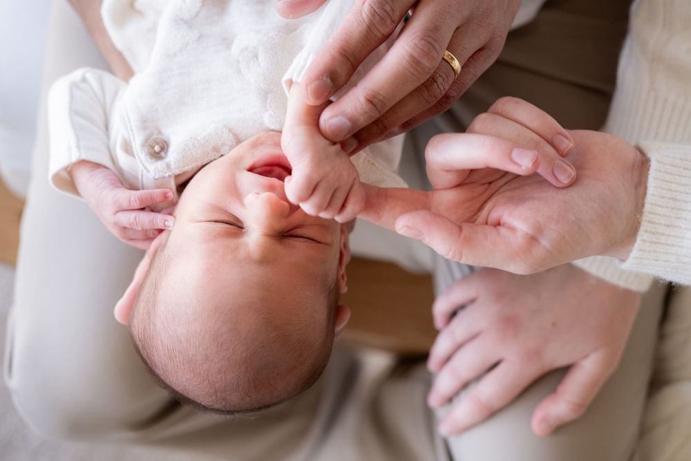Close-up shots of tiny baby hands and fingers being held by adult hands in a tender moment.