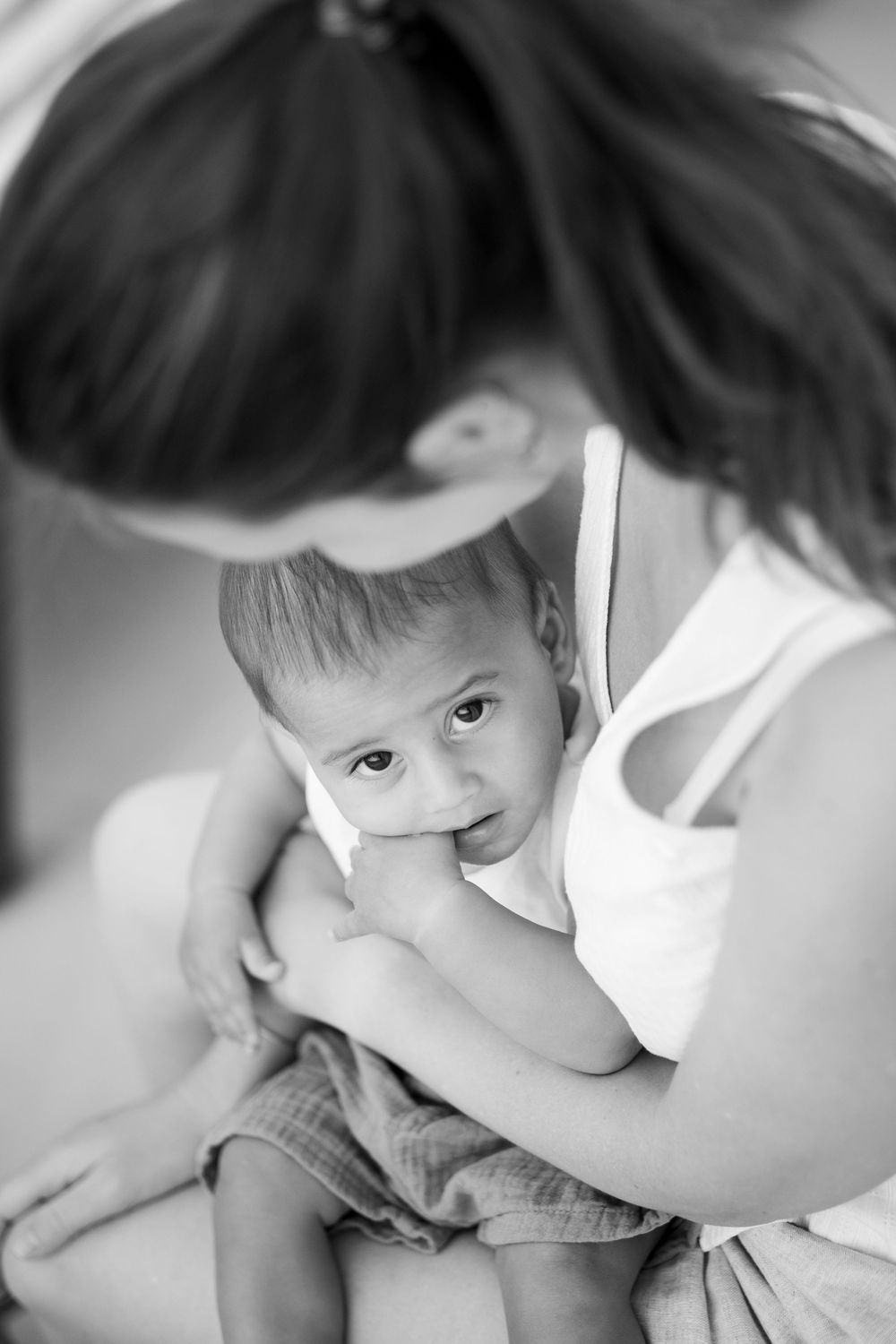 A tender breastfeeding moment captured in intimate black and white photography.