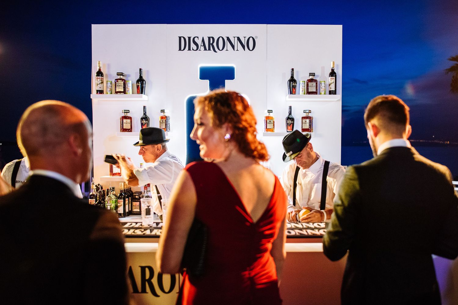Disaronno branded bar setup at an upscale event with bottles displayed against white backdrop.