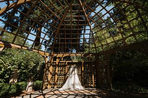 Rustic barn interior with wooden beams and natural sunlight streaming through the roof structure.
