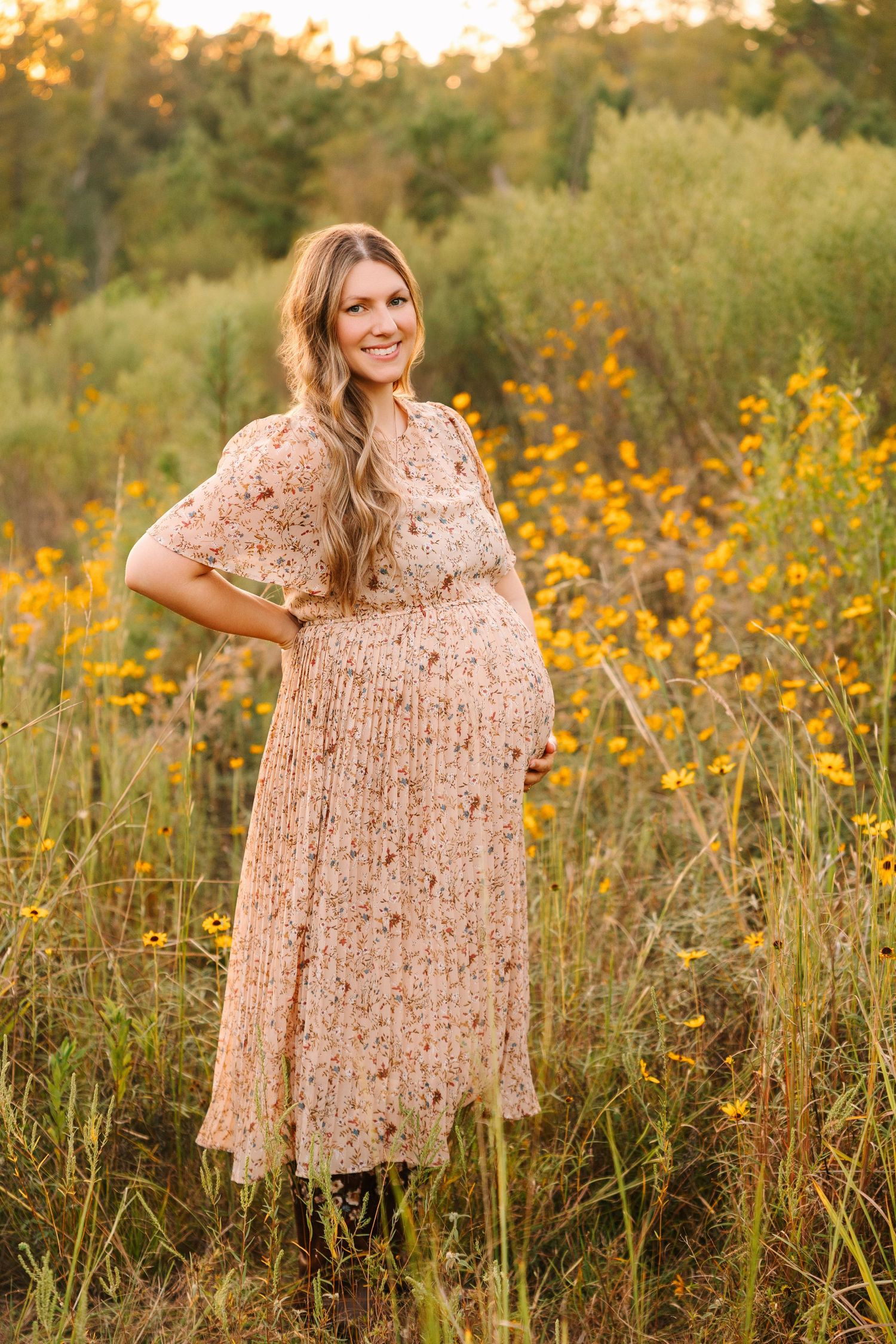 A floral dress is captured in a golden field of wildflowers during sunset, creating a dreamy autumn setting.