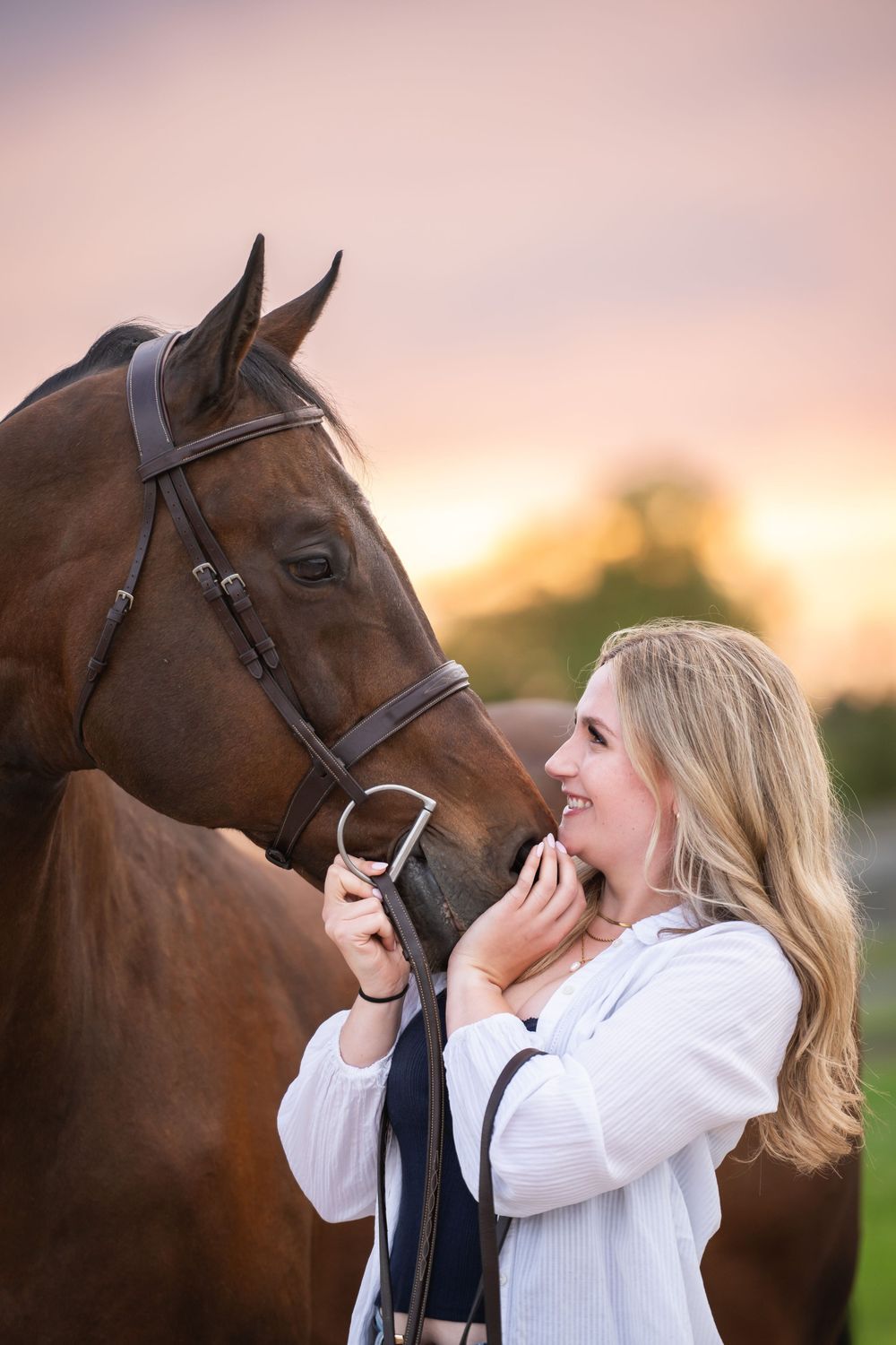 Woman in white sweater shares tender moment with brown horse against sunset sky in five sequential photos.