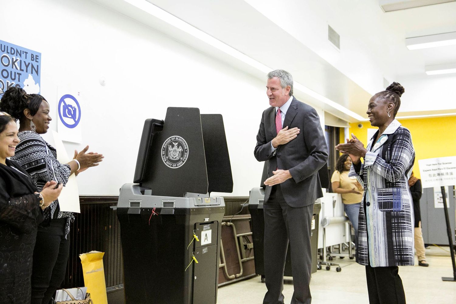 People line up to cast their votes at a polling station with electronic voting machines during an election.