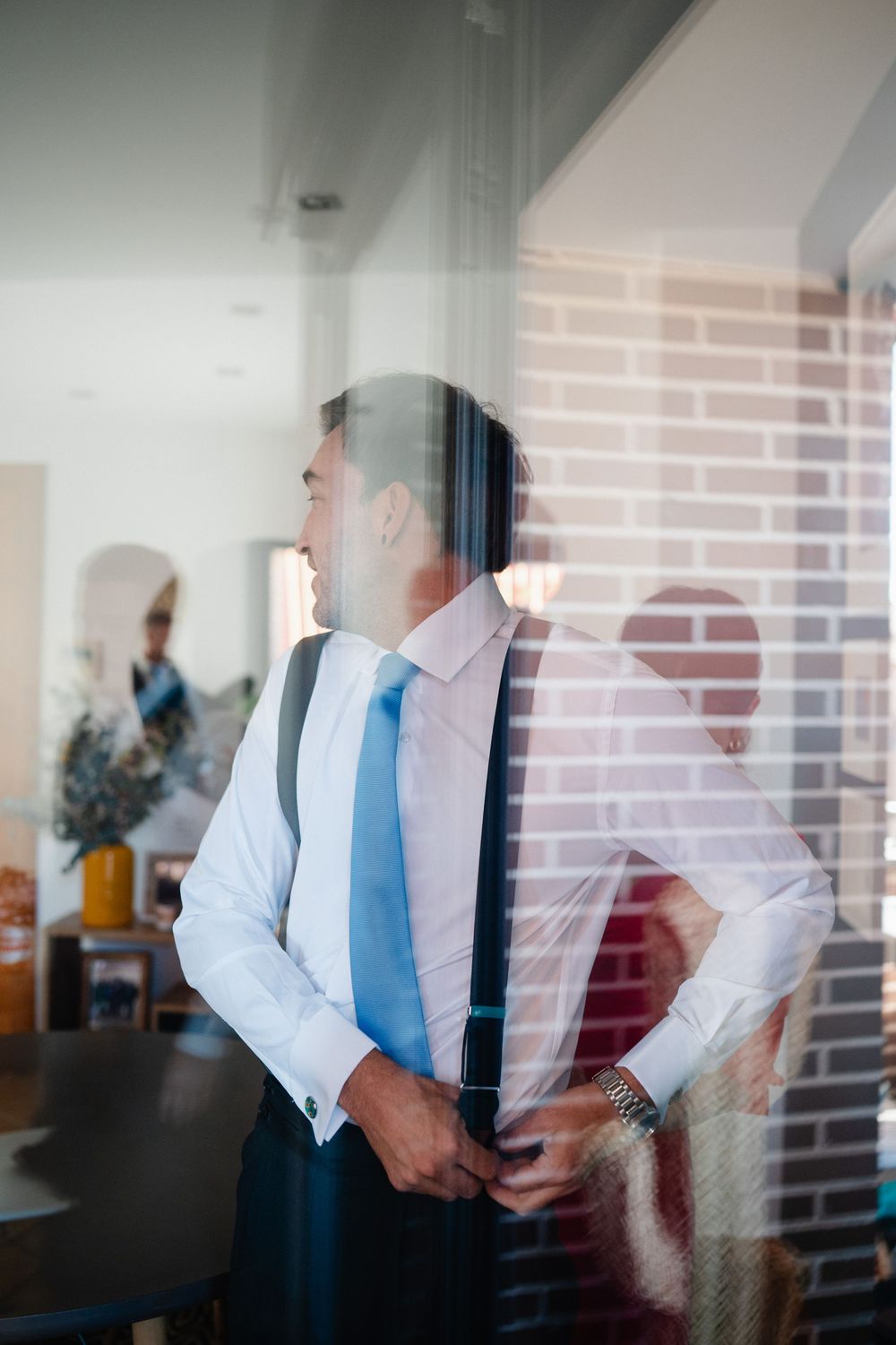 A sequence of motion blur photos showing a figure in a white shirt and blue tie gradually leaning backwards against a window.