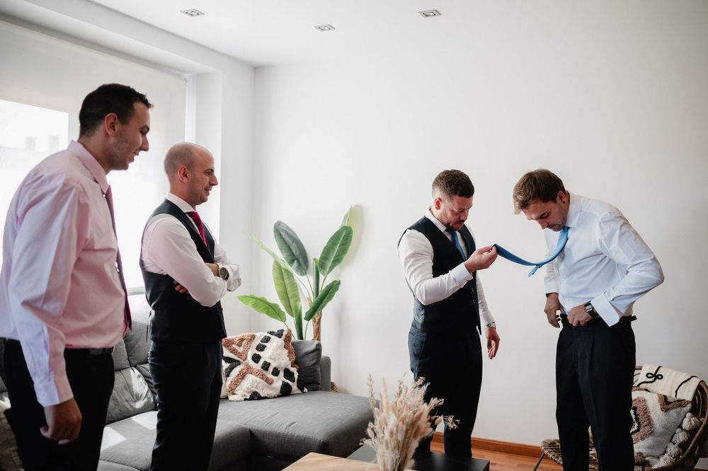 A sequence of people getting dressed and preparing in formal attire in a bright white room.