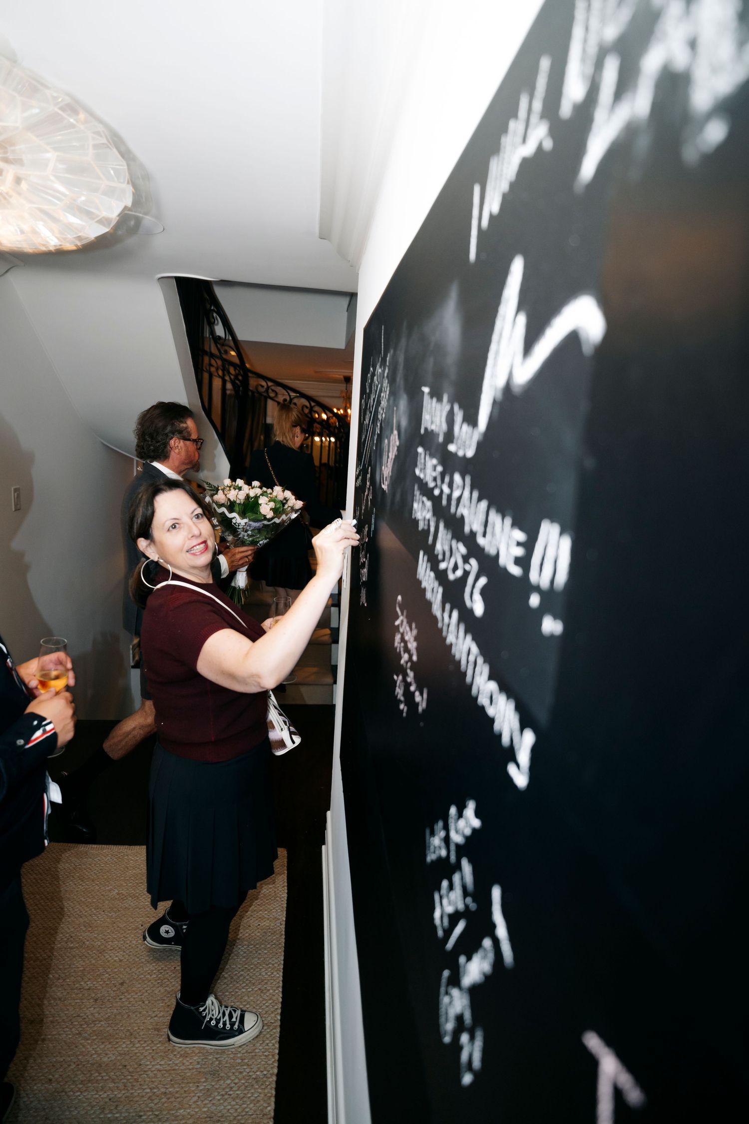 A sequence of photos showing someone writing with chalk on a dark wall.