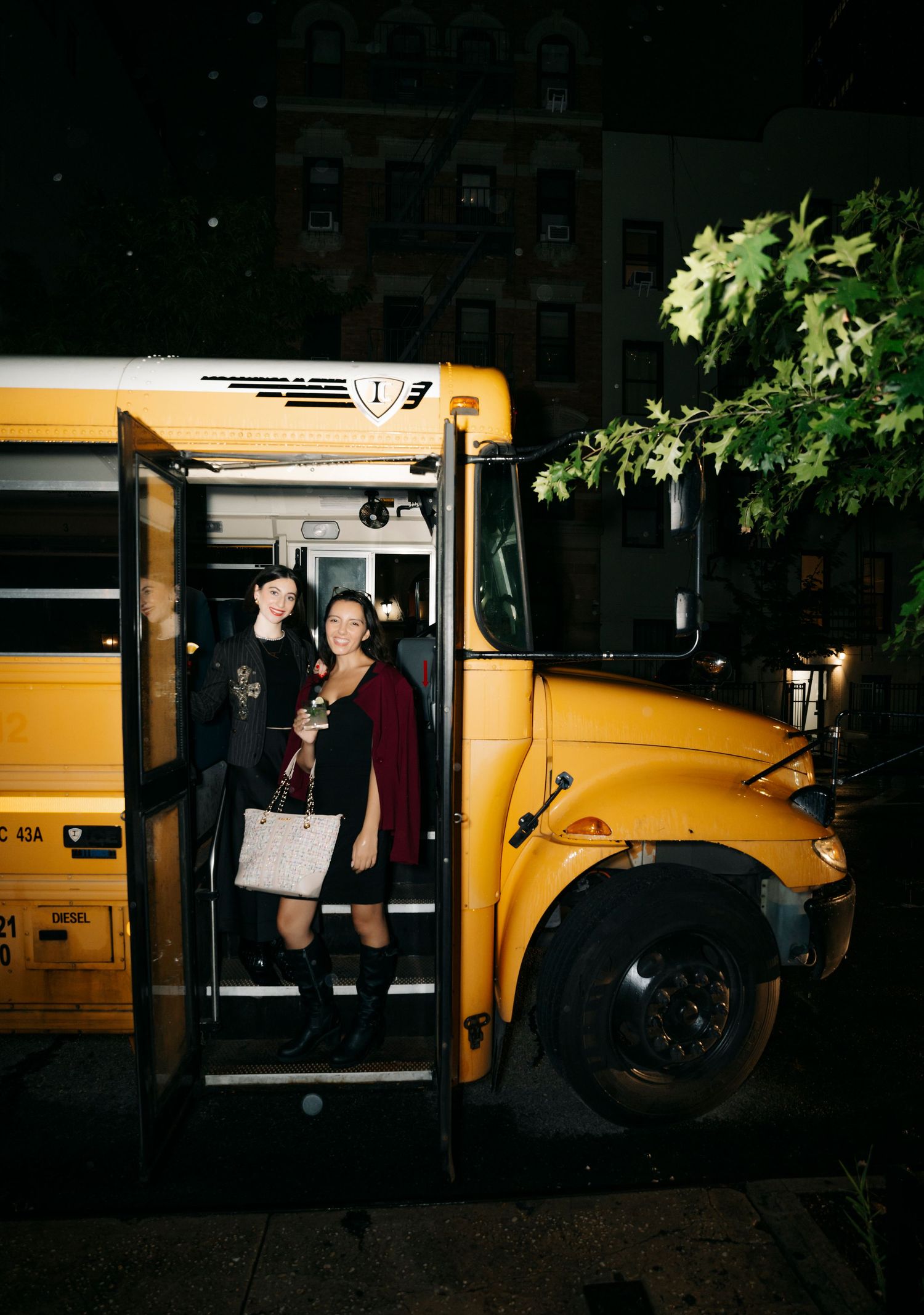 Yellow school bus at night with people entering and exiting.