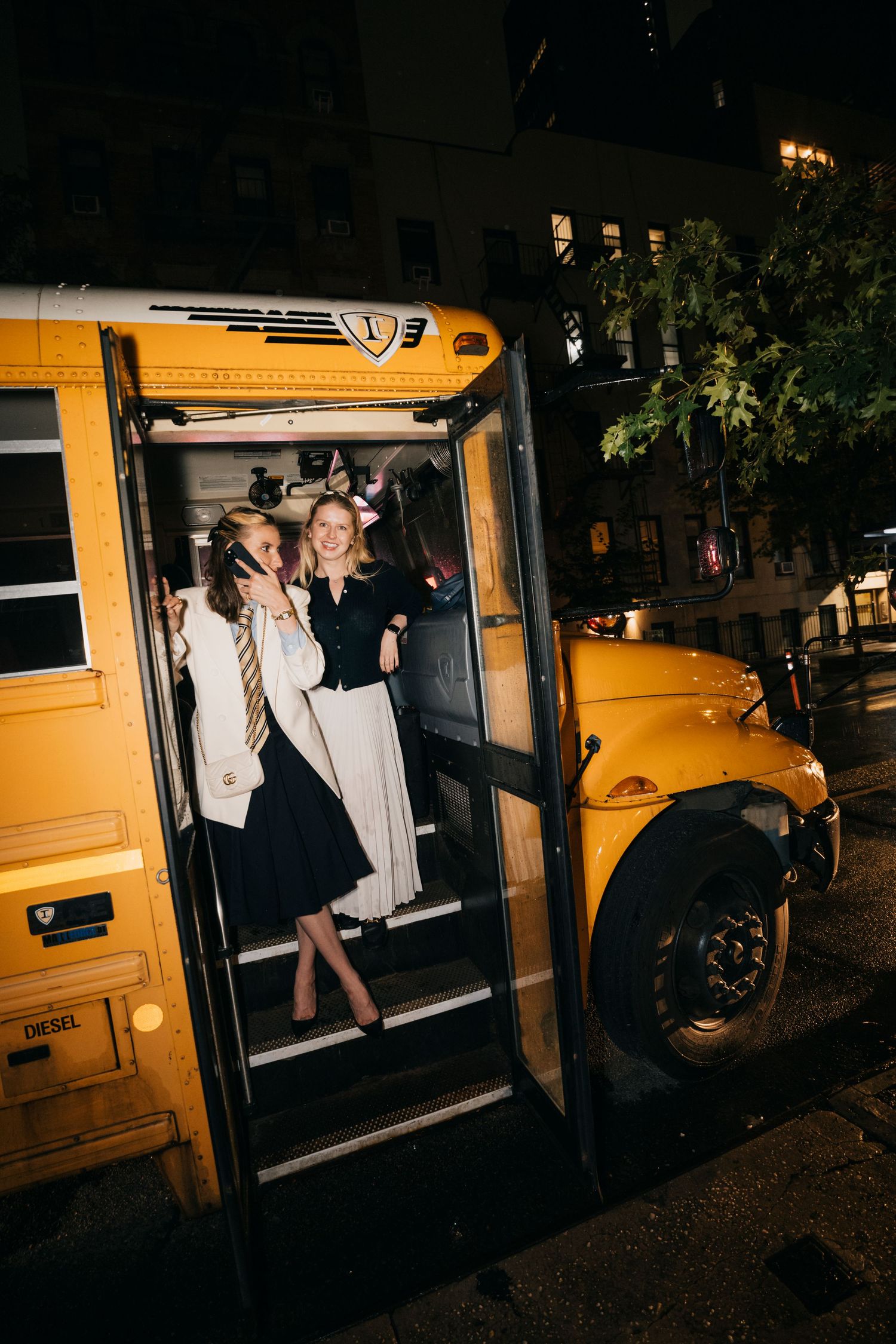 Yellow school bus door opens at night as passengers exit after an event.
