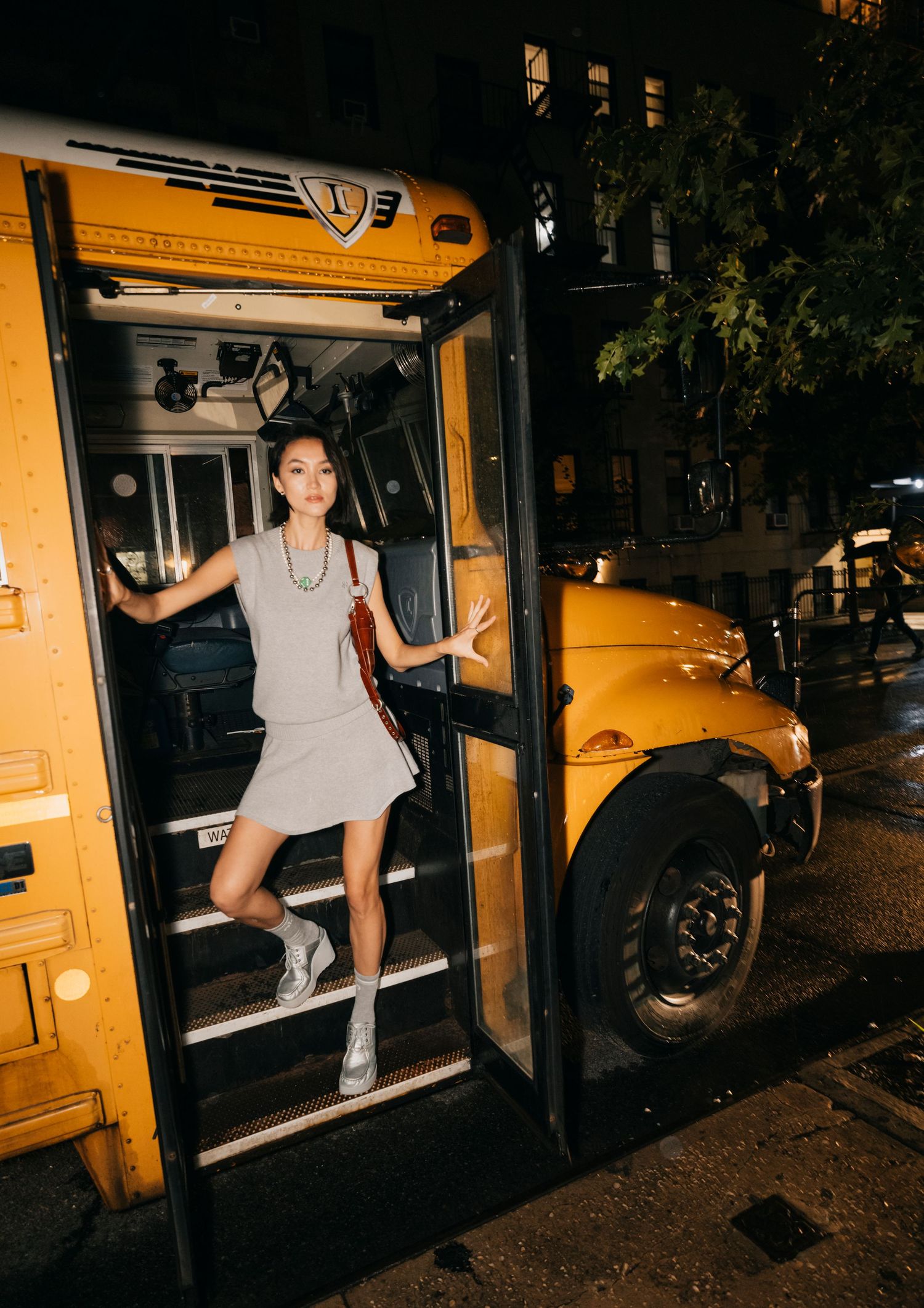 A sequence of nighttime photos showing someone playfully exiting a yellow school bus in different poses.
