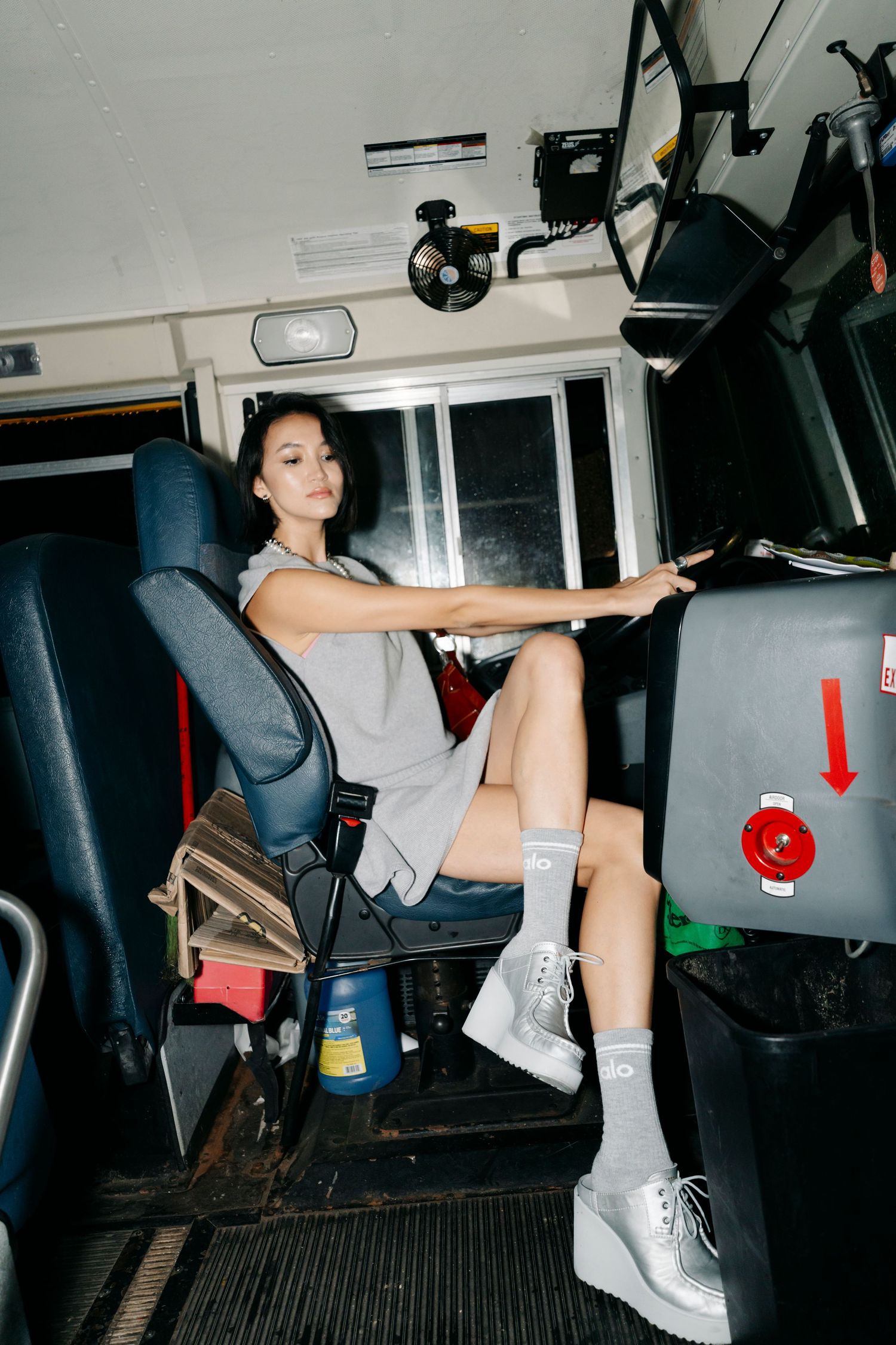 Athletic figure performs acrobatic moves inside what appears to be a vehicle or bus.