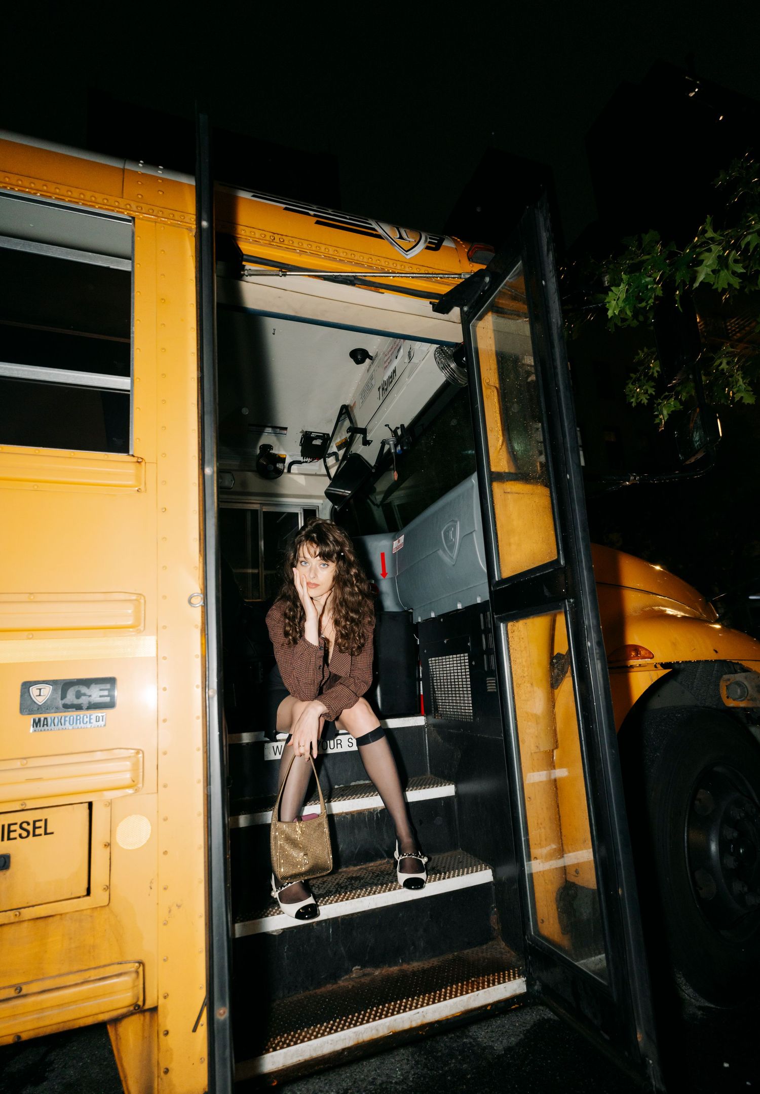Sequential shots of a yellow diesel bus at night with people climbing aboard.