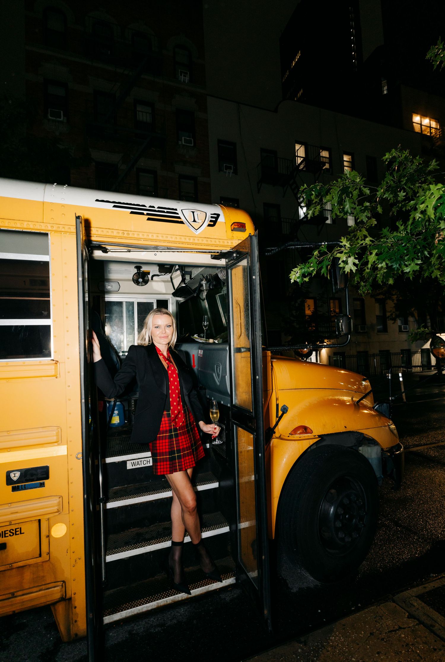 People entering and exiting a yellow school bus during a nighttime event.