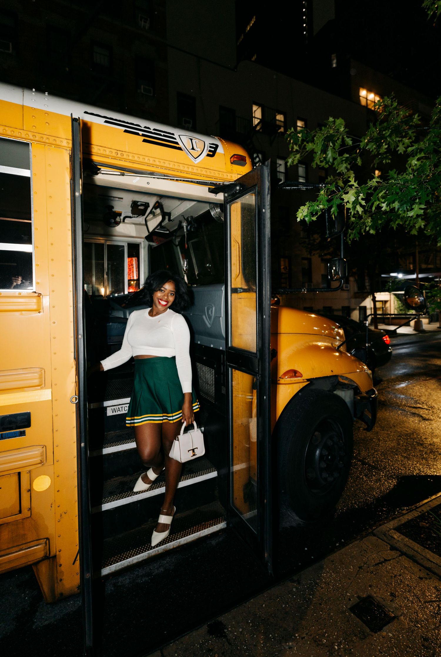 Several people board a yellow school bus in darkness.