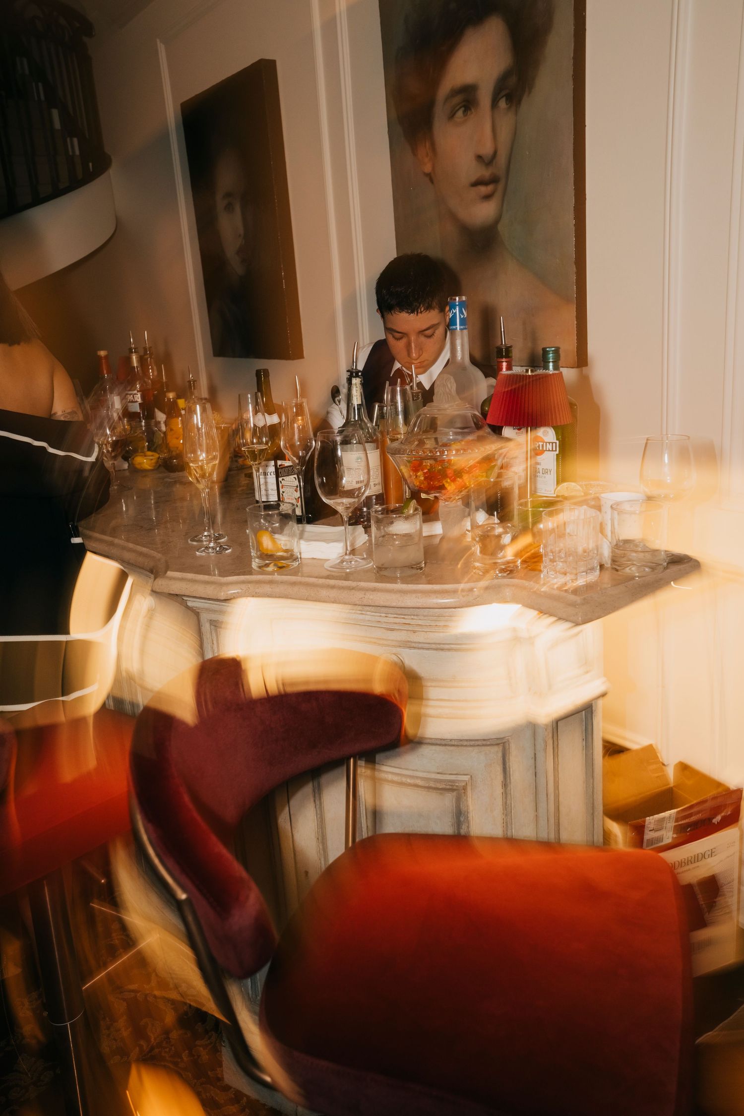 Blurred artistic photos of a bar counter with wine glasses and bottles in warm lighting.