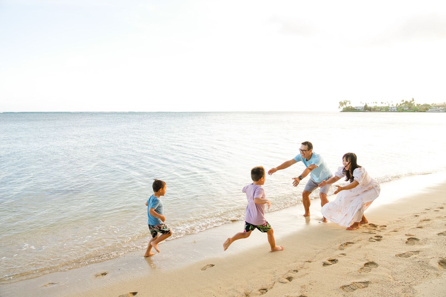 Three children play and splash in the shallow waves at the beach on a sunny day in Oahu
Oahu family photography, Hawaii family photographer,
