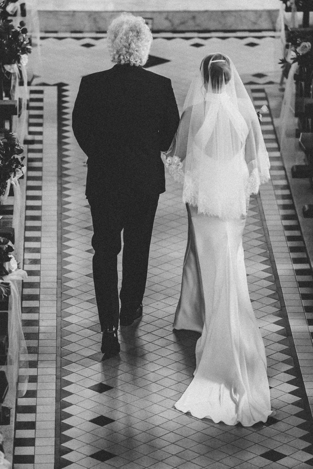 A series of four monochrome images showing a bride in white dress and groom in dark suit walking from behind on tiled floor.