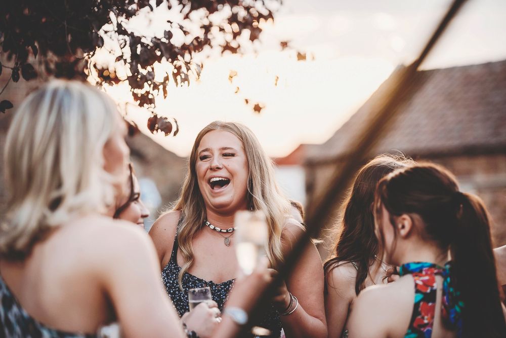 Group of friends enjoying an outdoor celebration with golden hour sunlight creating a warm, festive atmosphere.