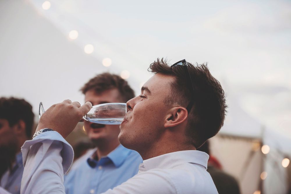 An animated sequence shows a person in a light gray shirt tipping their head back while drinking from a blue water bottle.