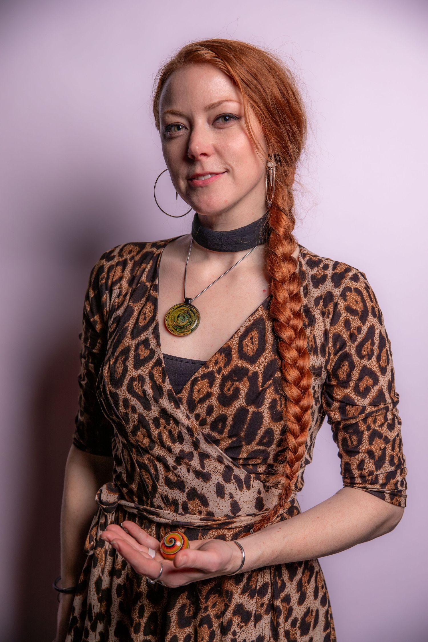 Animal print dress styled with statement necklace against purple backdrop.