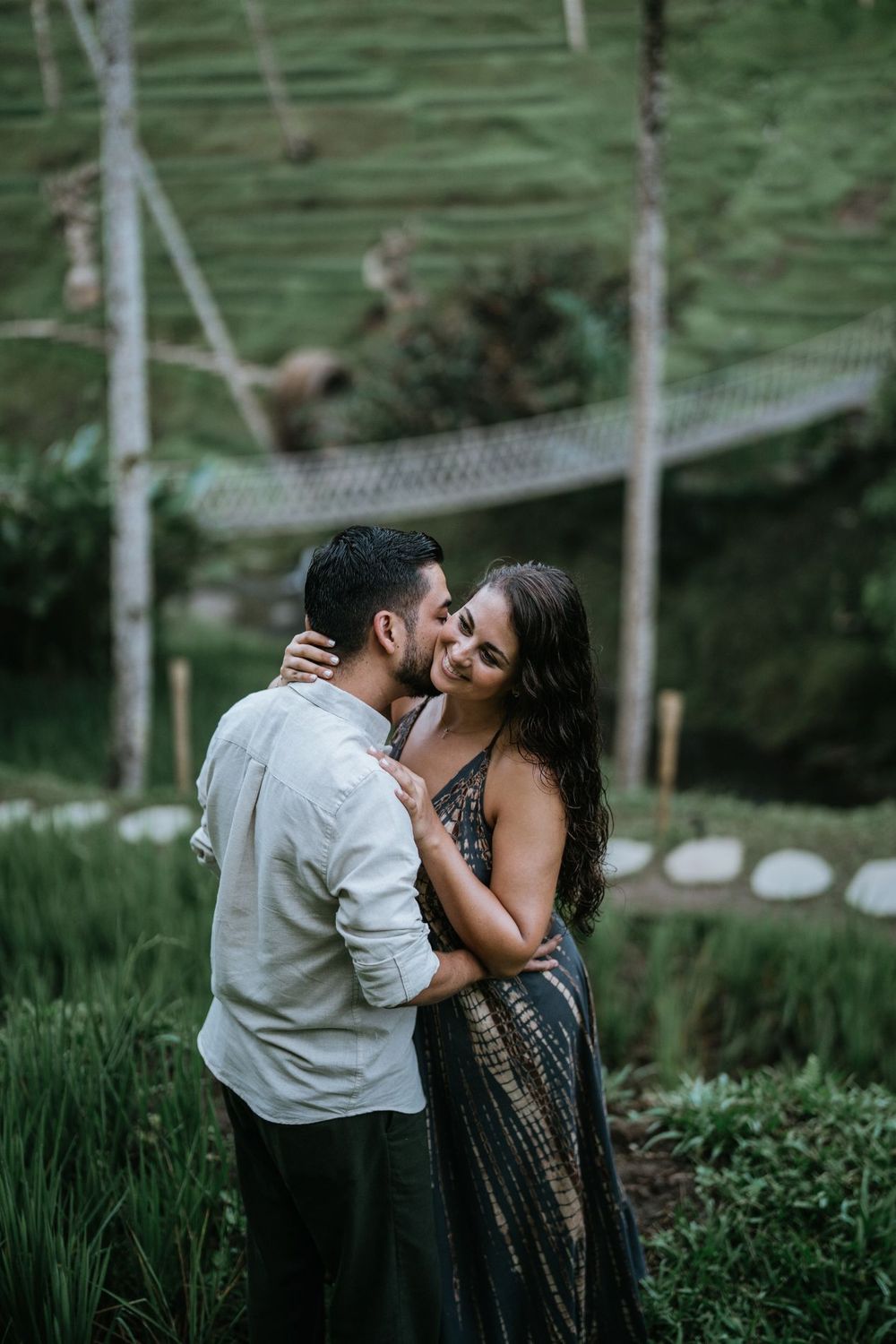 Romantic moment captured between couple in a lush tropical garden setting.