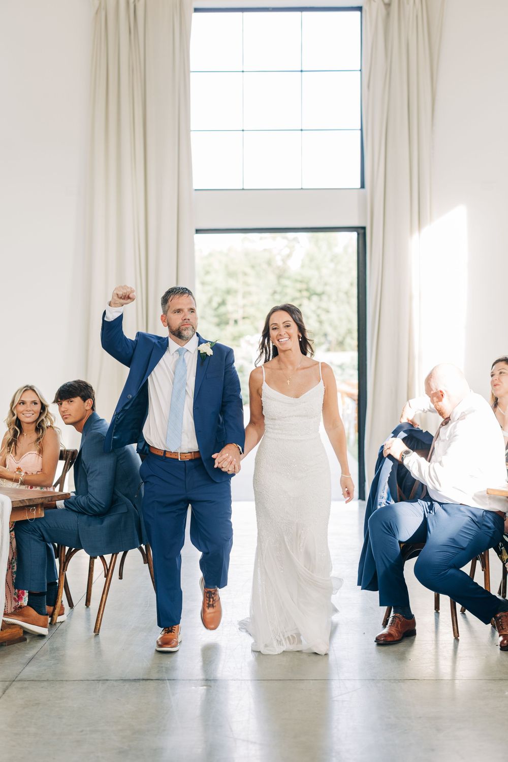 Wedding party sequence showing playful seated dance poses in coordinating navy suits and white dresses.