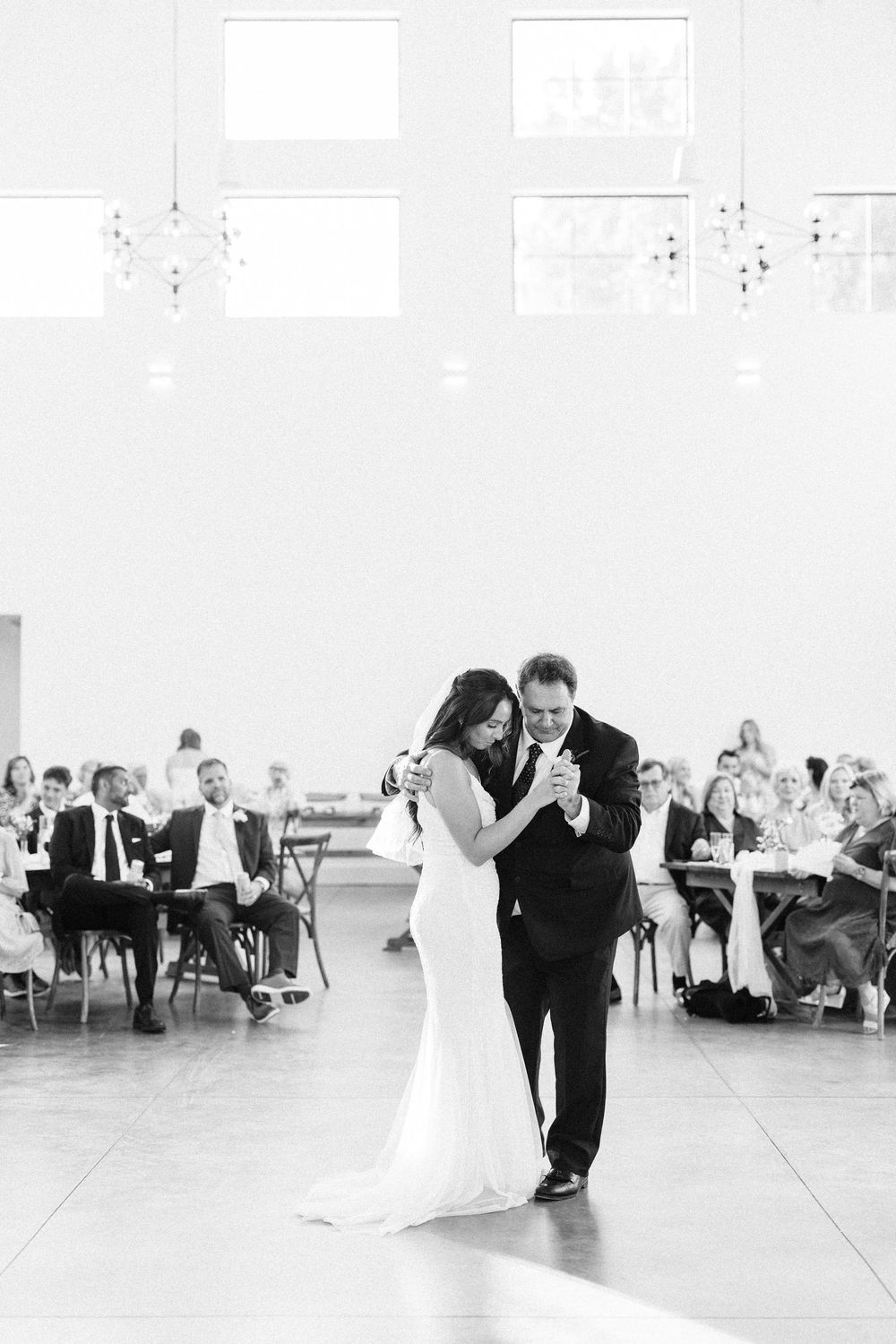 A sequence of black and white wedding photos showing a couple's romantic first dance in an elegant reception hall.