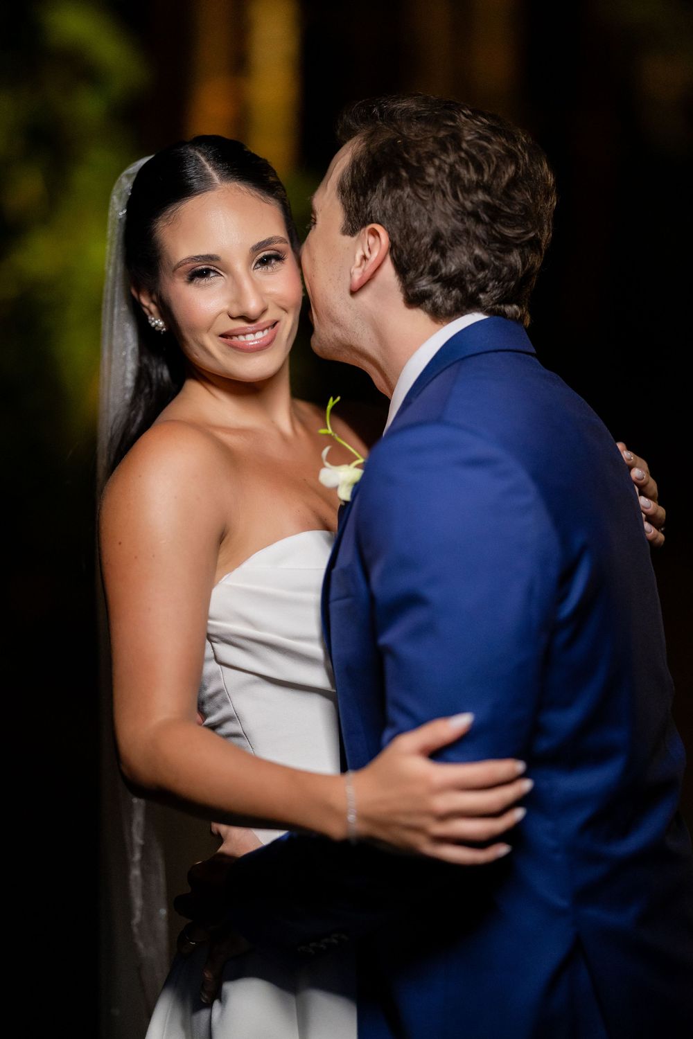 A romantic series of wedding photos showing a couple embracing with the bride in white and groom in navy blue.