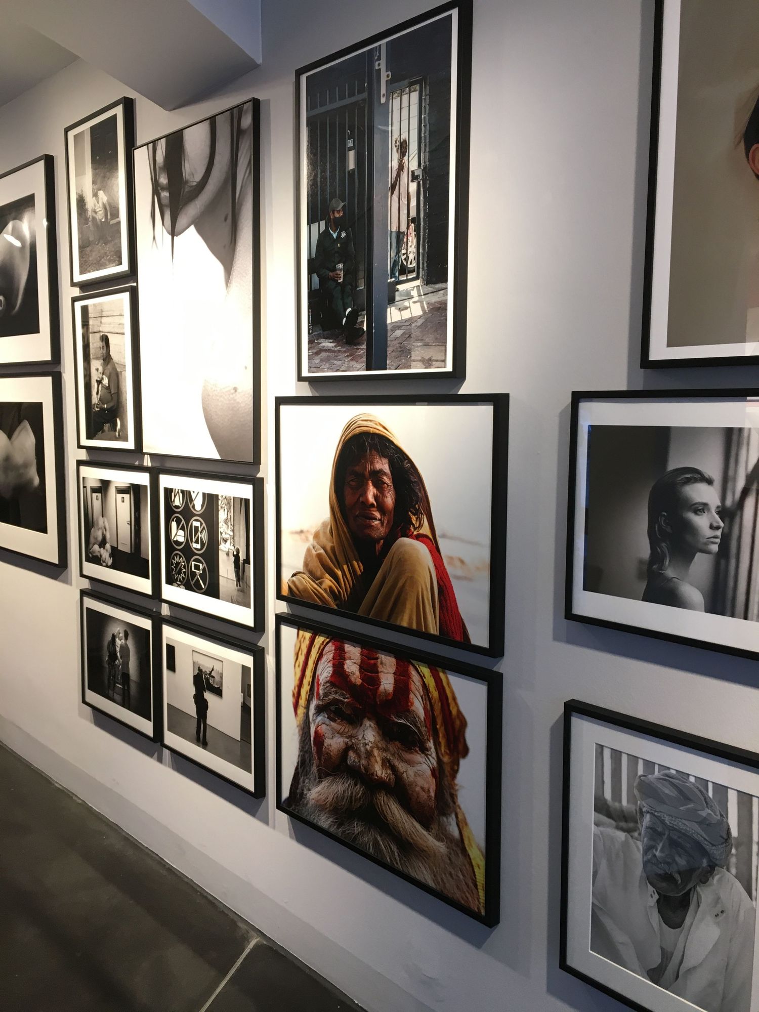 Text-filled black frames and exhibits displayed on a white gallery wall with dramatic lighting effects.