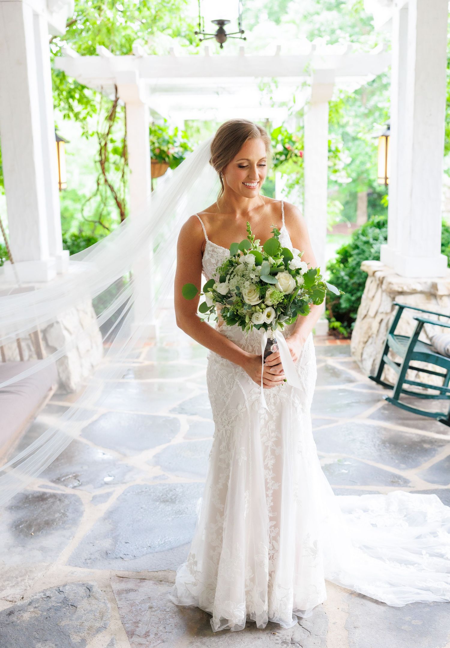 Series of wedding portraits showing flowing veil movement on an elegant front porch with white columns and greenery at Big Cedar Lodge.
