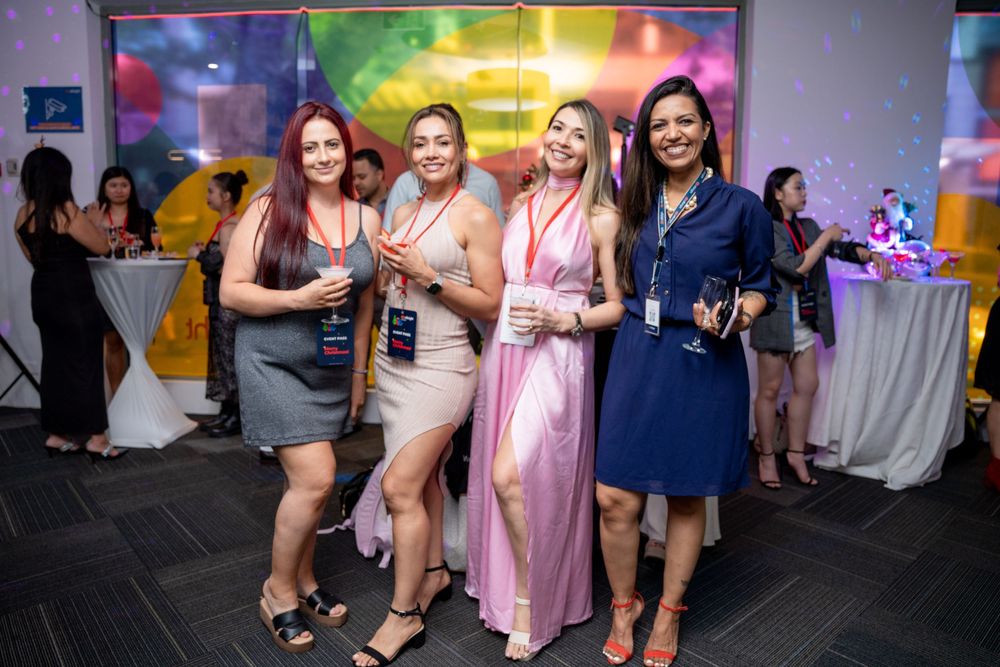 Group gathering under colorful lighting at evening social event with casual atmosphere.