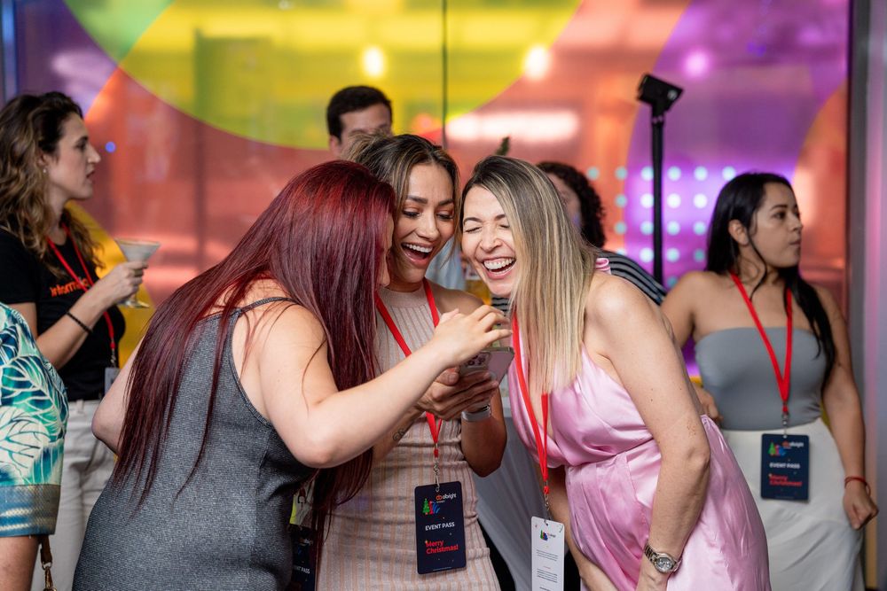 Vibrant social gathering with people mingling under multicolored lighting effects.
