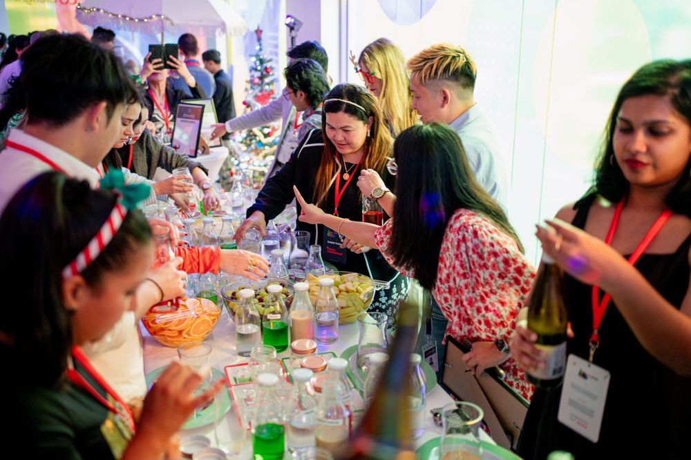Event attendees seated at decorated tables enjoying drinks and conversation.
