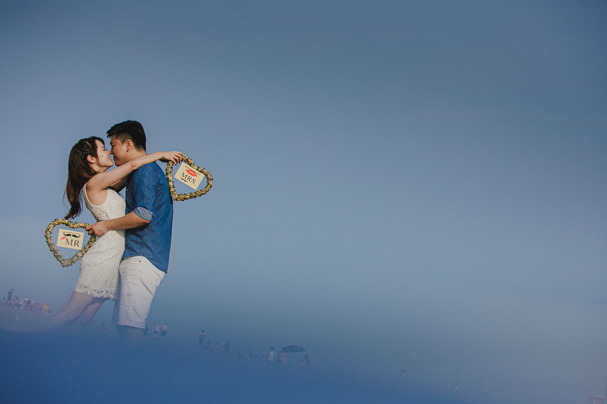 A couple embraces in a romantic dance pose against a dreamy blue background.