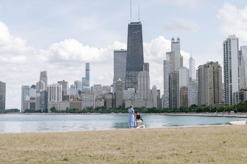 Chicago skyline stretches across the horizon with Lake Michigan in the foreground on a clear sunny day.
