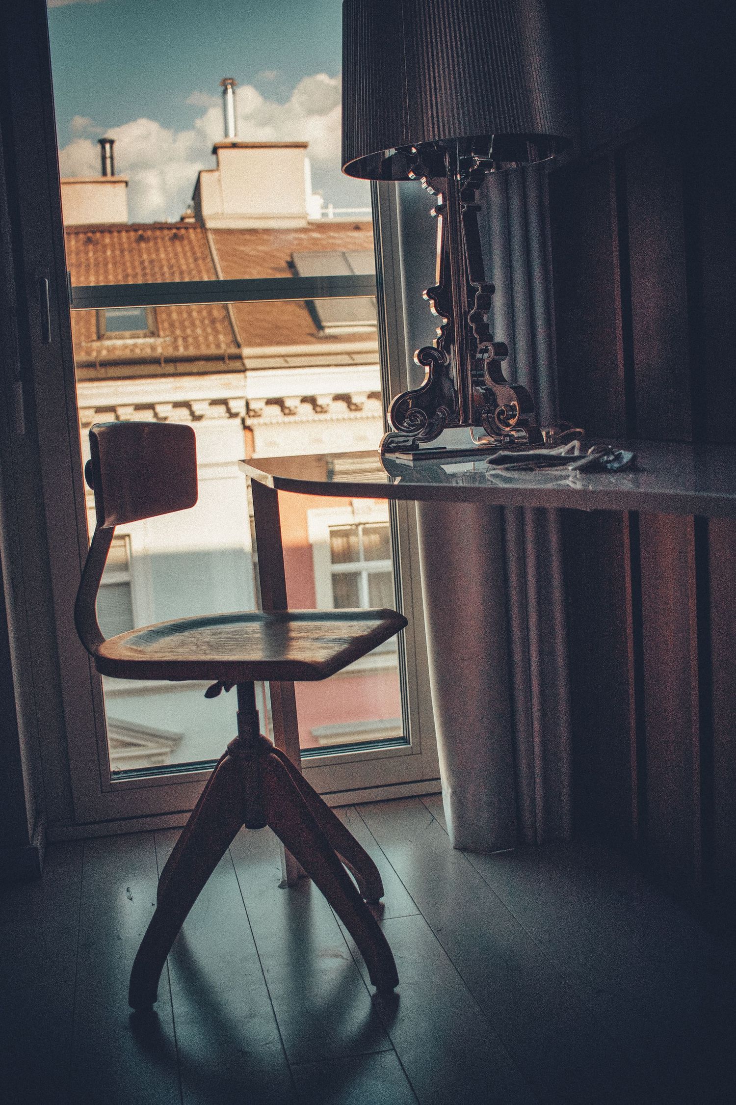 A series of vintage wooden furniture silhouettes against a window with natural daylight streaming in.