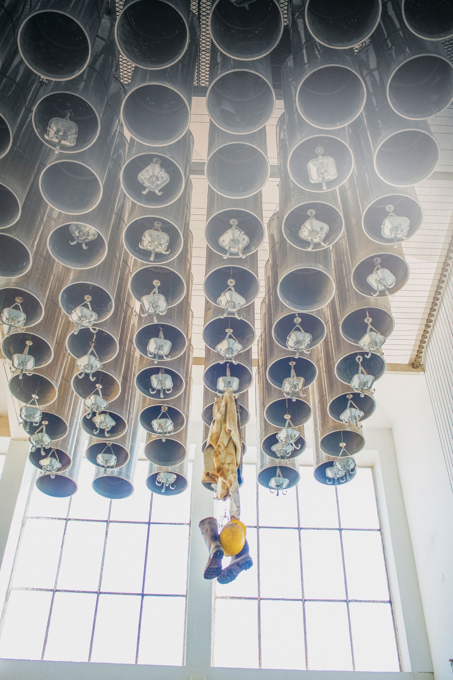 Multiple decorative blue glass pendant lamps hang from a modern white ceiling in a repeating geometric pattern.