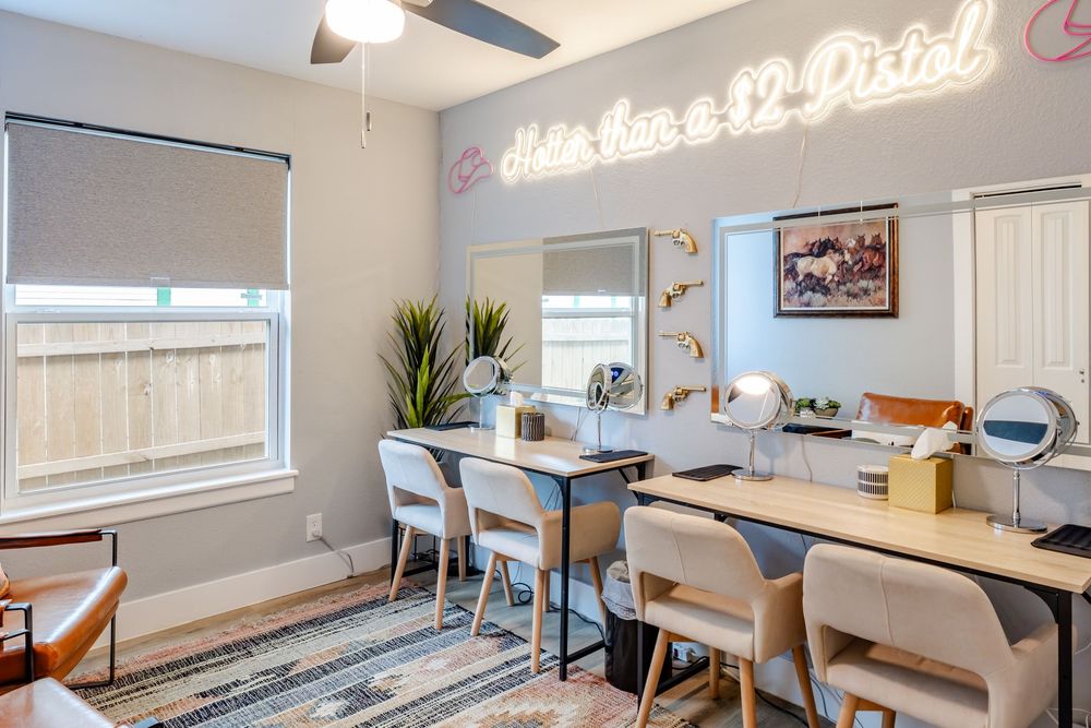 Modern dining room features a sleek grey table with beige chairs and stylish pendant lighting in an open concept space.