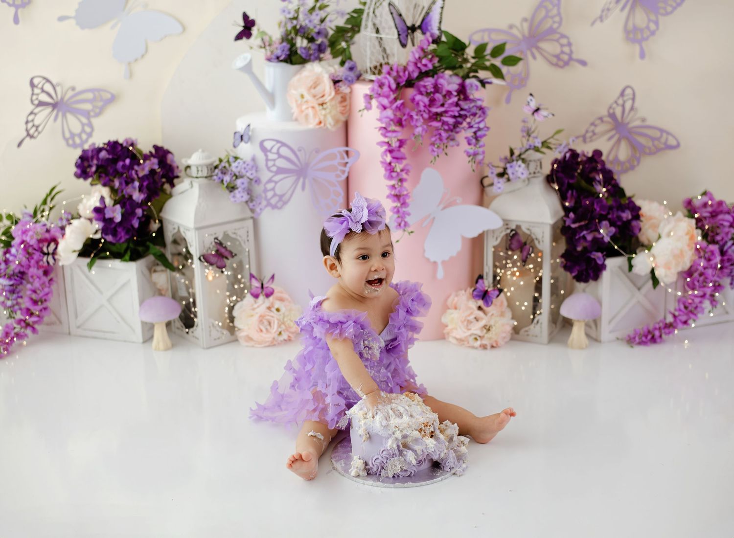 A delicate purple and white floral arrangement with butterflies creates a romantic horizontal border composition.
