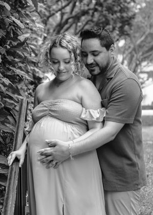 A couple shares tender moments together in a garden setting with black and white tones.