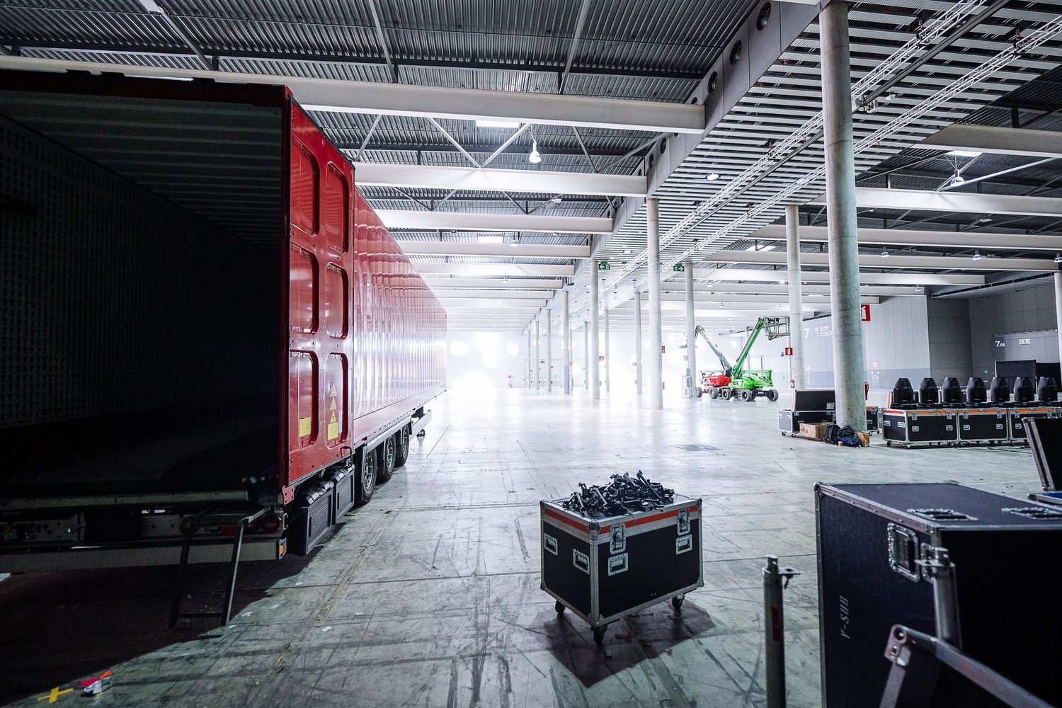 Large empty warehouse space with industrial lighting and concrete floors.