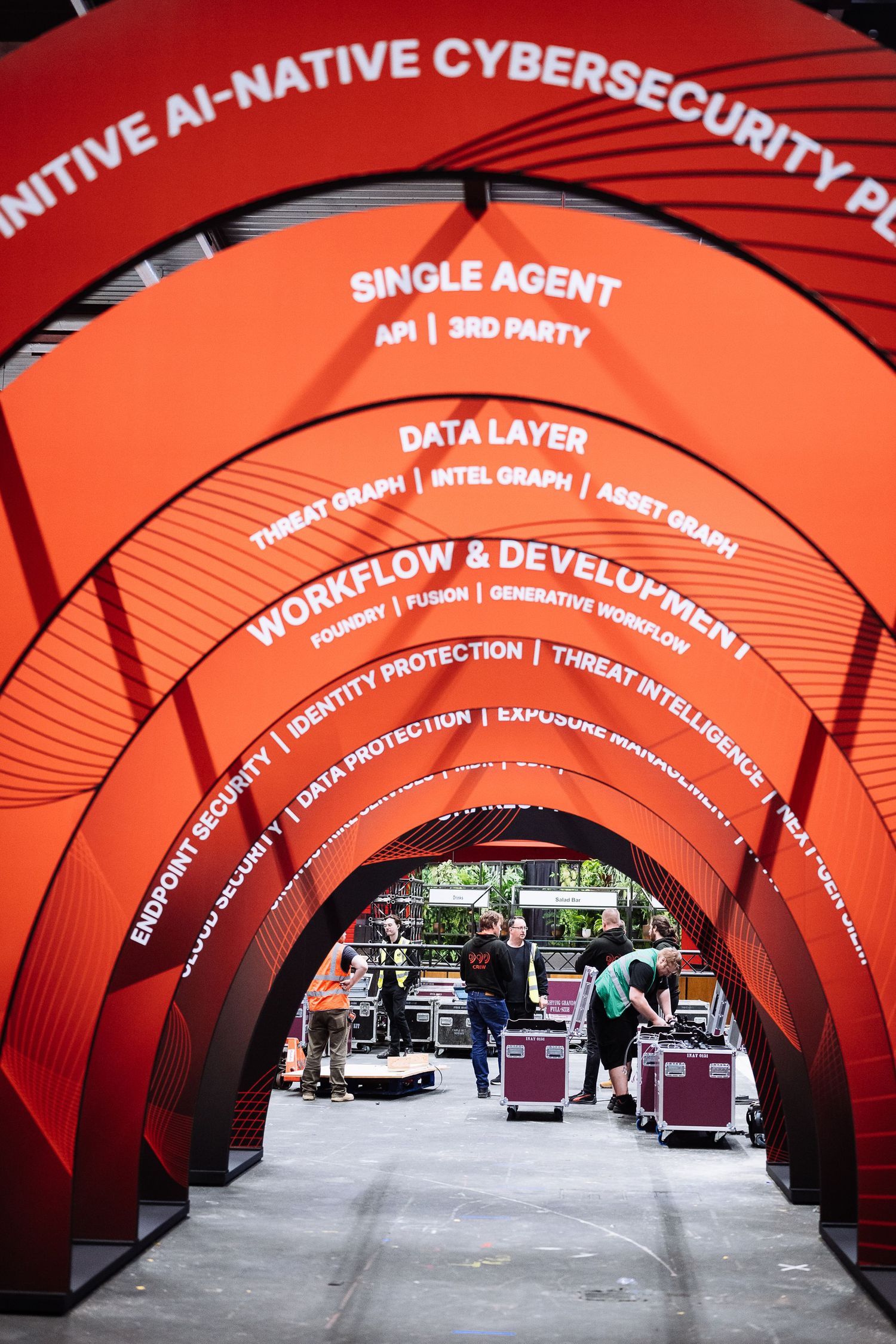 Red curved architectural tunnel with cybersecurity and AI-related text displays.