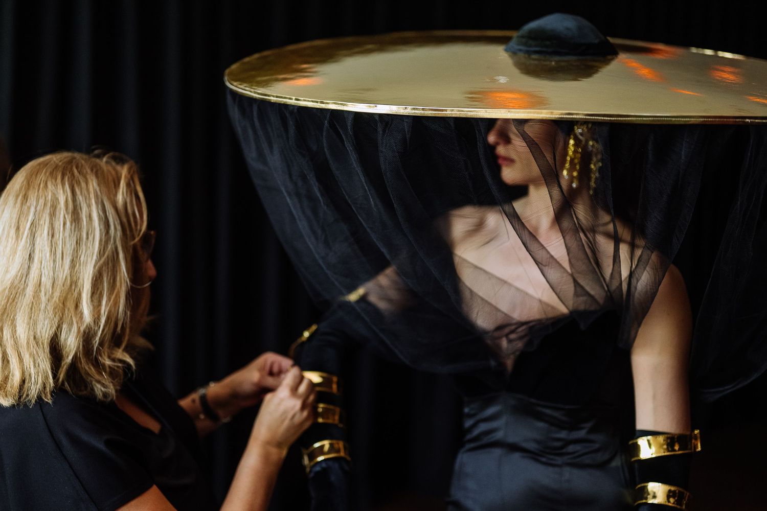 Musicians performing on stage with dramatic backlighting and cymbals visible.