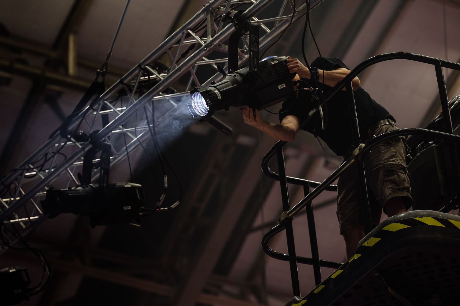 Industrial lighting grid and technical equipment mounted on theater ceiling.