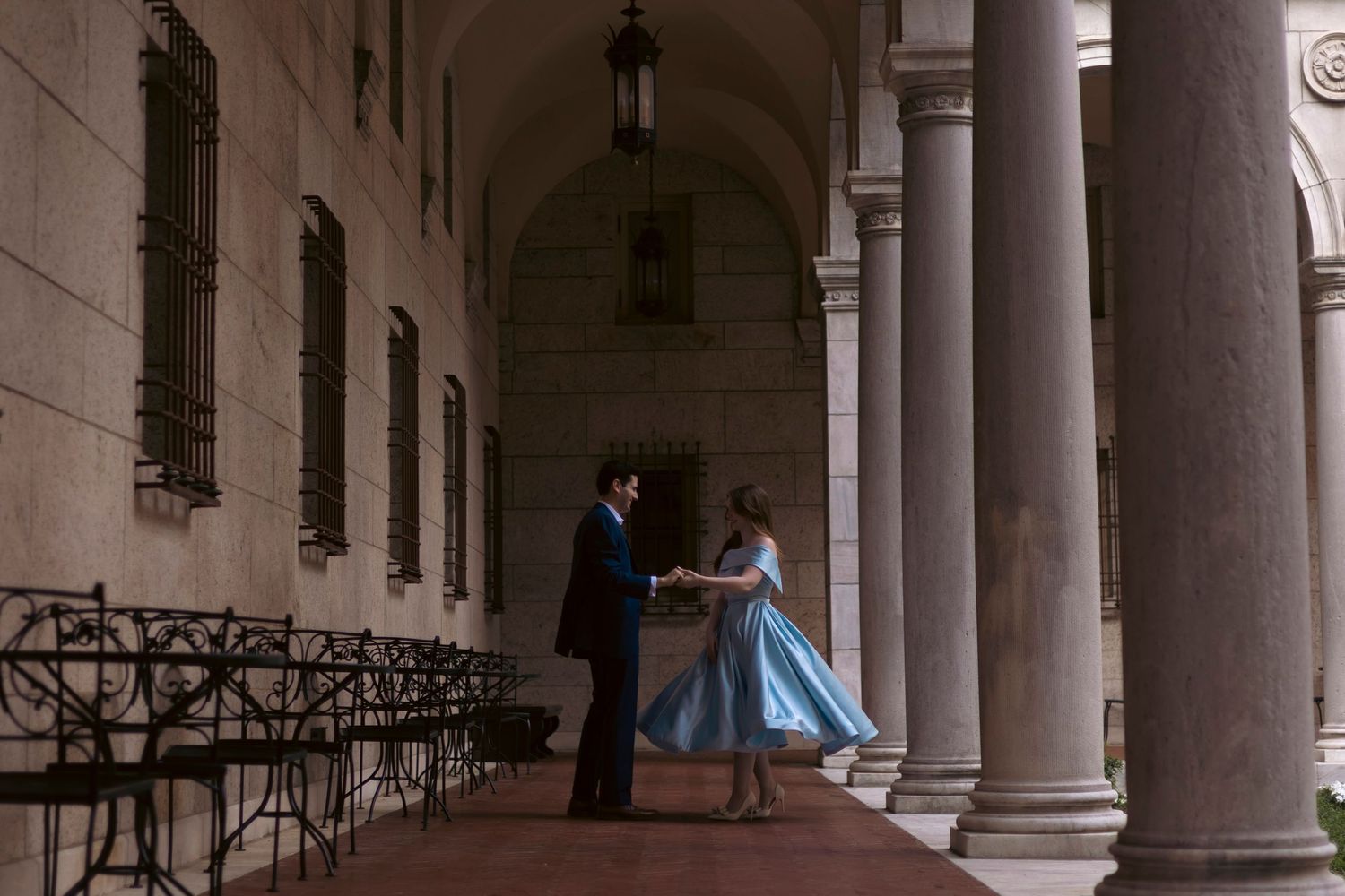 Long row of white neoclassical columns casting shadows in an elegant covered arcade or portico.