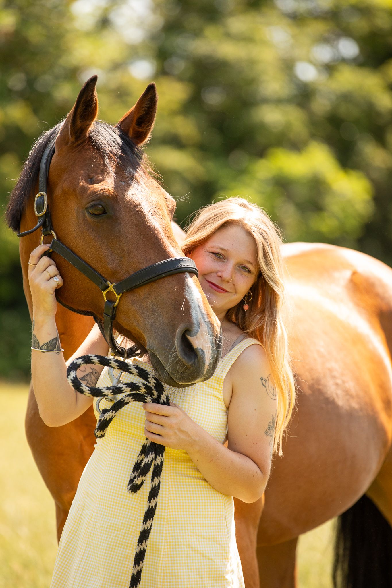 A beautiful black and white paint horse stands with a person on a sunny autumn day outdoors.
