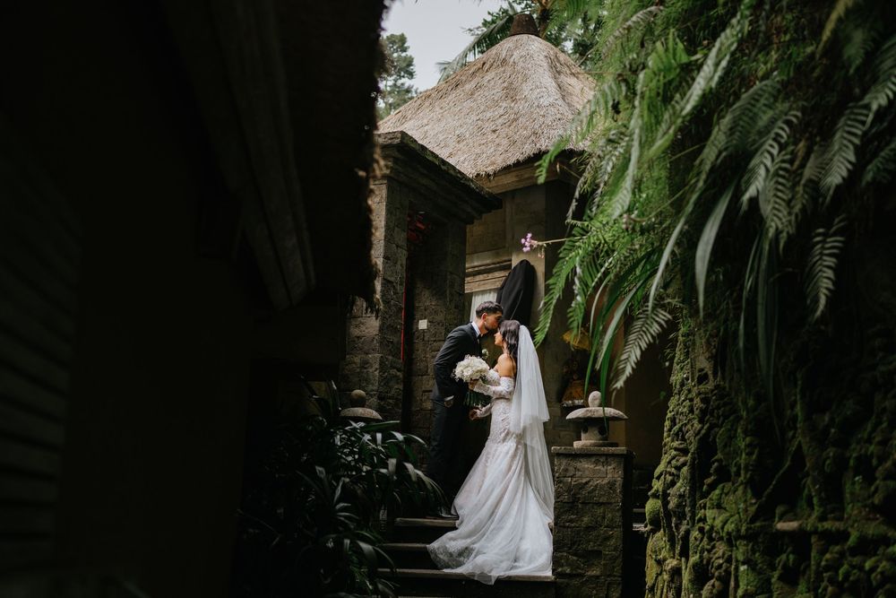 A romantic wedding scene in a lush tropical garden setting.