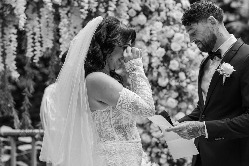 Wedding ceremony under cascading white floral arrangements with elegant decor.
